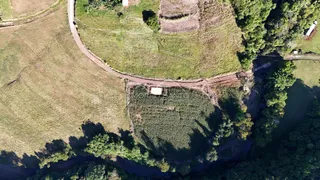 Vista aérea de uma área rural com campos cultivados e vegetação densa em Lajeado.