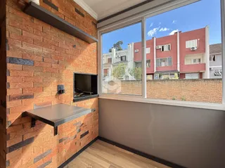 Parede de tijolos aparentes com uma grande janela de vista para a rua.