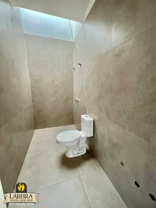 Foto de um banheiro com paredes revestidas de cerâmica e um vaso sanitário branco.