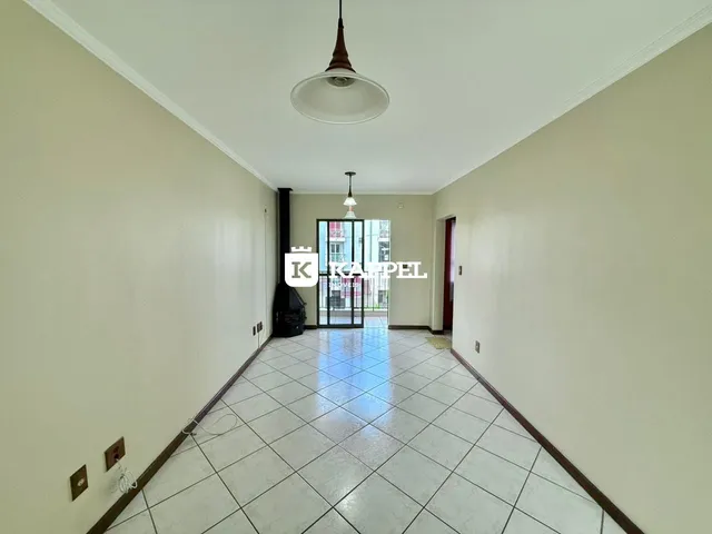 Corredor interno com piso de cerâmica e paredes claras.