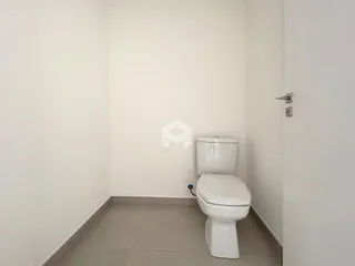 Foto de um banheiro com paredes brancas e piso de cerâmica.