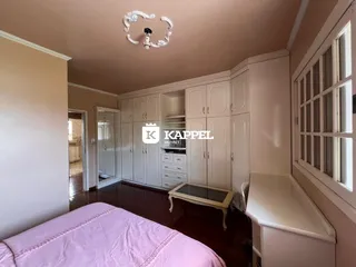Quarto com cama e armários brancos em um imóvel.