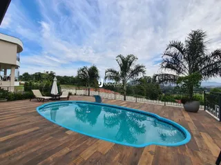 Vista de uma piscina e deck de madeira em uma propriedade.