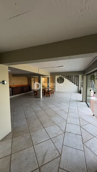 Área interna com piso de cerâmica e teto branco em uma residência.