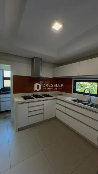 A cozinha apresenta armários brancos e piso cerâmico.