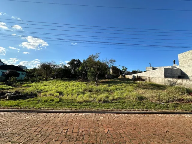 Vista externa de uma propriedade com vegetação rasteira e uma estrutura de concreto no fundo.