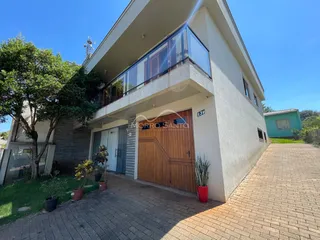 Fachada de uma casa em Lajeado, Brasil, mostrando a entrada e um terraço no andar superior.