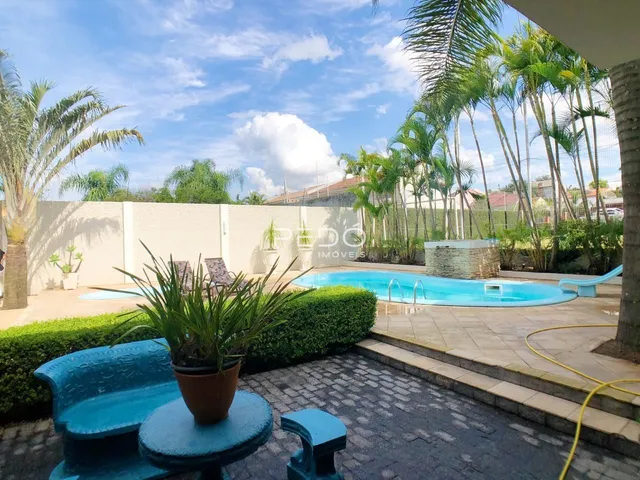 Vista externa de uma piscina e jardim em uma propriedade no Brasil.