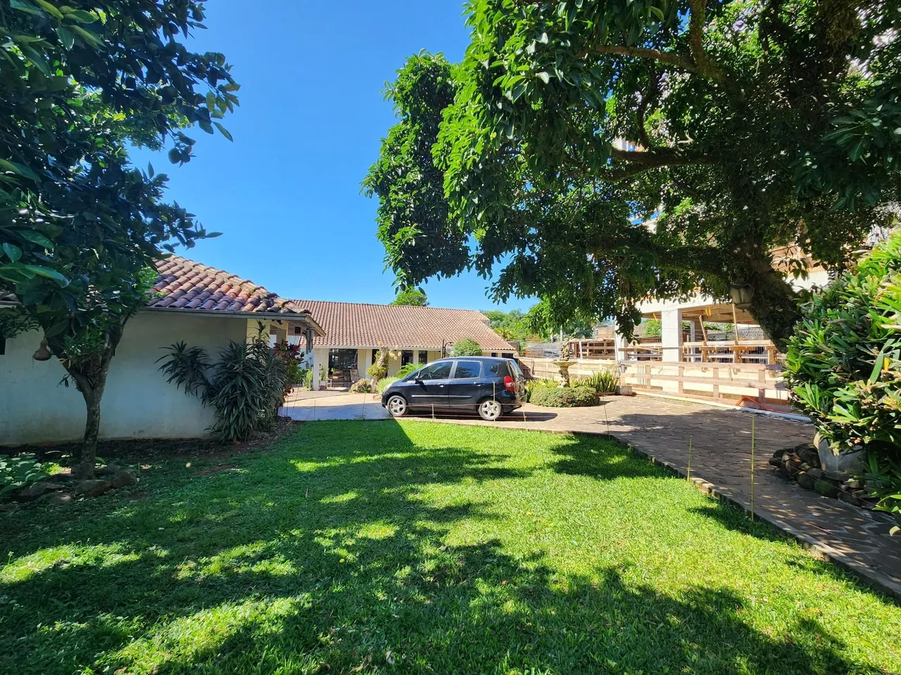 Fachada da casa em Lajeado, Brasil, mostrando o jardim gramado e a área externa.