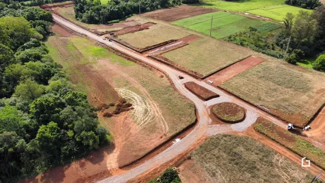 Vista aérea de uma propriedade rural com campos e estradas de terra.