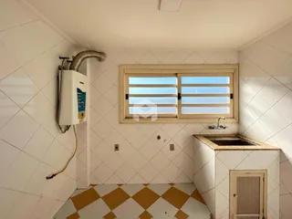 Imagem de um ambiente interno com piso xadrez e azulejos brancos.
