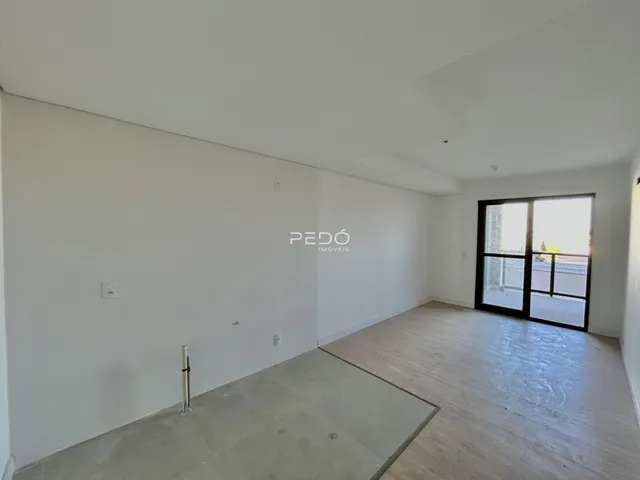 Ambiente interno de um imóvel com paredes brancas e piso de madeira em Lajeado.