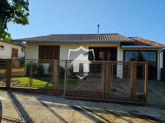 Fachada de uma residência em Lajeado, Brasil, com cerca e portão de madeira.