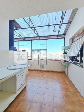 Sala com teto inclinado e piso de cerâmica.