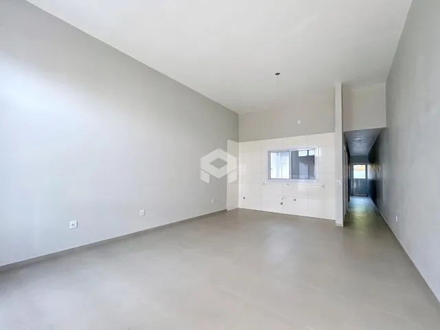 Espaço interno amplo com paredes brancas e piso claro.