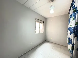 Interior de um cômodo com paredes cinzas e piso de cerâmica.