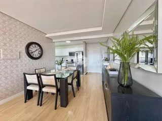 Foto de uma sala de jantar com piso de madeira clara e paredes texturizadas.