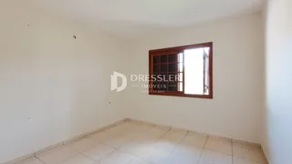 Ambiente interno de uma sala com piso de cerâmica e paredes brancas.