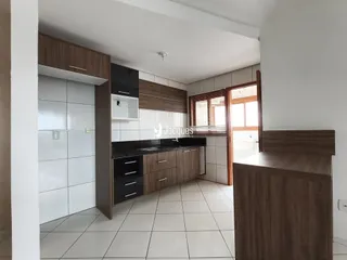 Vista interna de uma cozinha moderna com armários escuros e piso claro.