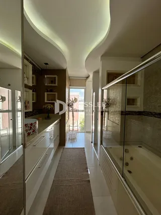 Hall de um imóvel em Lajeado, Brasil, mostrando um corredor e área de banheiro com box de vidro.