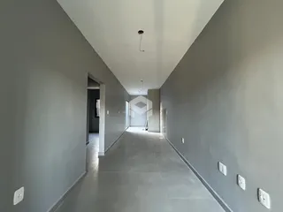 Corredor interno de uma residência com paredes cinzas e piso claro.