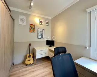 Ambiente interno de um imóvel com piso de madeira e móveis brancos.