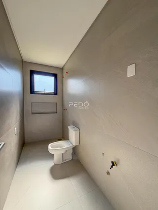 Corredor com janela e vaso sanitário em um imóvel.