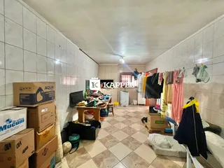 Corredor com paredes brancas e roupas penduradas ao longo da parede.