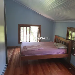 Quarto com cama de madeira e piso de madeira.