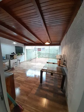 Vista interna de uma sala com piso de madeira e teto de madeira.