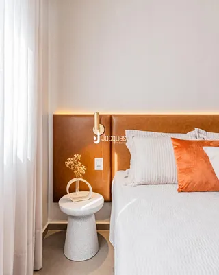 Quarto com cabeceira estofada marrom e decoração moderna.