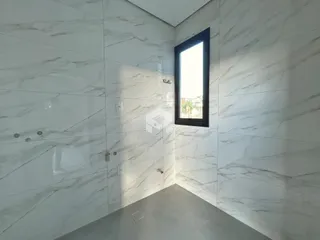 Vista interna de um corredor com revestimento de mármore branco nas paredes.