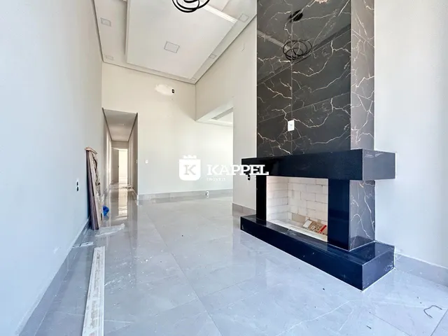 Corredor interno com piso de porcelanato e lareira de mármore em ambiente residencial.