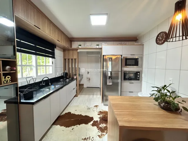 Foto da cozinha com armários de madeira e eletrodomésticos em um imóvel.