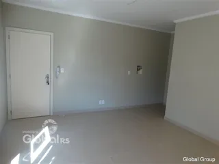 Ambiente interno de uma sala vazia com paredes cinzas e piso claro.