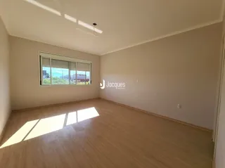 Sala de estar com piso de madeira clara e janela.