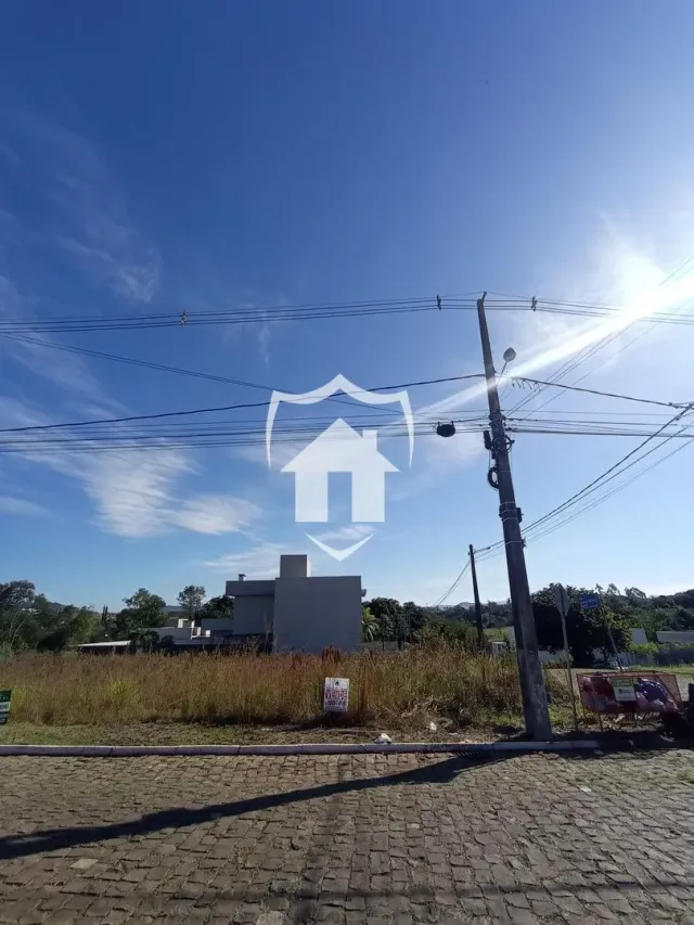 Vista externa de uma residência com vegetação seca no primeiro plano.