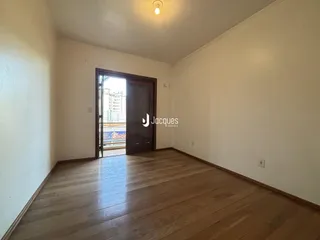 Ambiente interno com piso de madeira e porta de entrada.