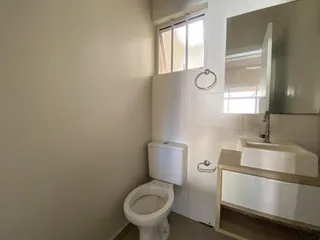 Foto de um banheiro mostrando um vaso sanitário e uma pia de bancada.