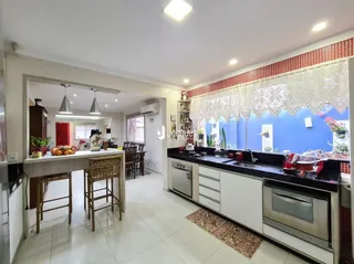 Imagem de uma cozinha com armários e bancadas brancas em Lajeado.