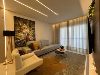 Sala de estar moderna com sofá e decoração clara.