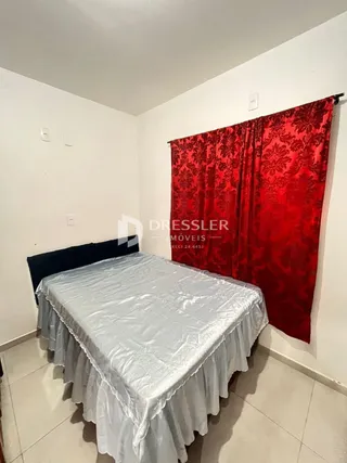 Quarto com cama coberta por lençol branco.