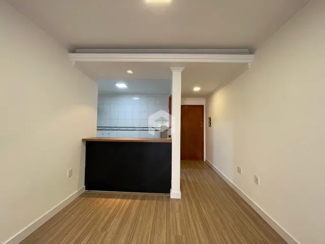 Hall da propriedade em Lajeado com paredes brancas e piso de madeira.