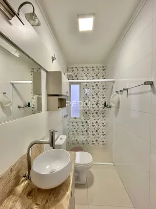 Banheiro com piso e paredes brancas e azulejos