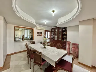 Sala de jantar com mesa e cadeiras em um ambiente claro.