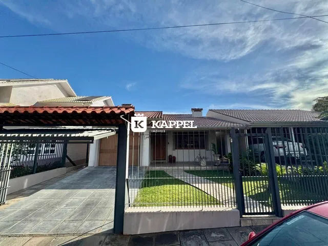 Vista externa de uma residência com cerca e jardim.