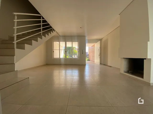 Vista de um hall com escadaria e piso de cerâmica.