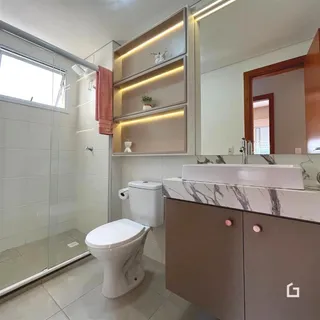 Foto interna de um banheiro moderno com revestimento de azulejo branco e bancada de mármore.