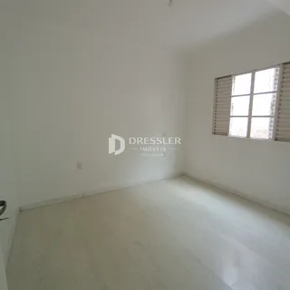 Foto de um ambiente interno com piso de madeira clara e paredes brancas.