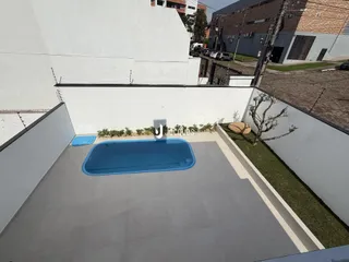 Vista de uma piscina externa em um pátio de imóvel.